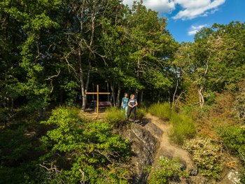 Drohnenaufnahme von Wanderinnen am Bergkreuz des Weltendepfades.