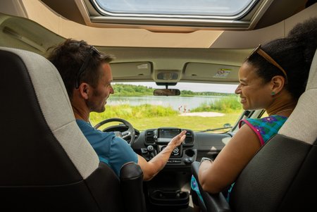 Mann auf dem Fahrersitz und Frau auf dem Beifahrersitz fotografiert