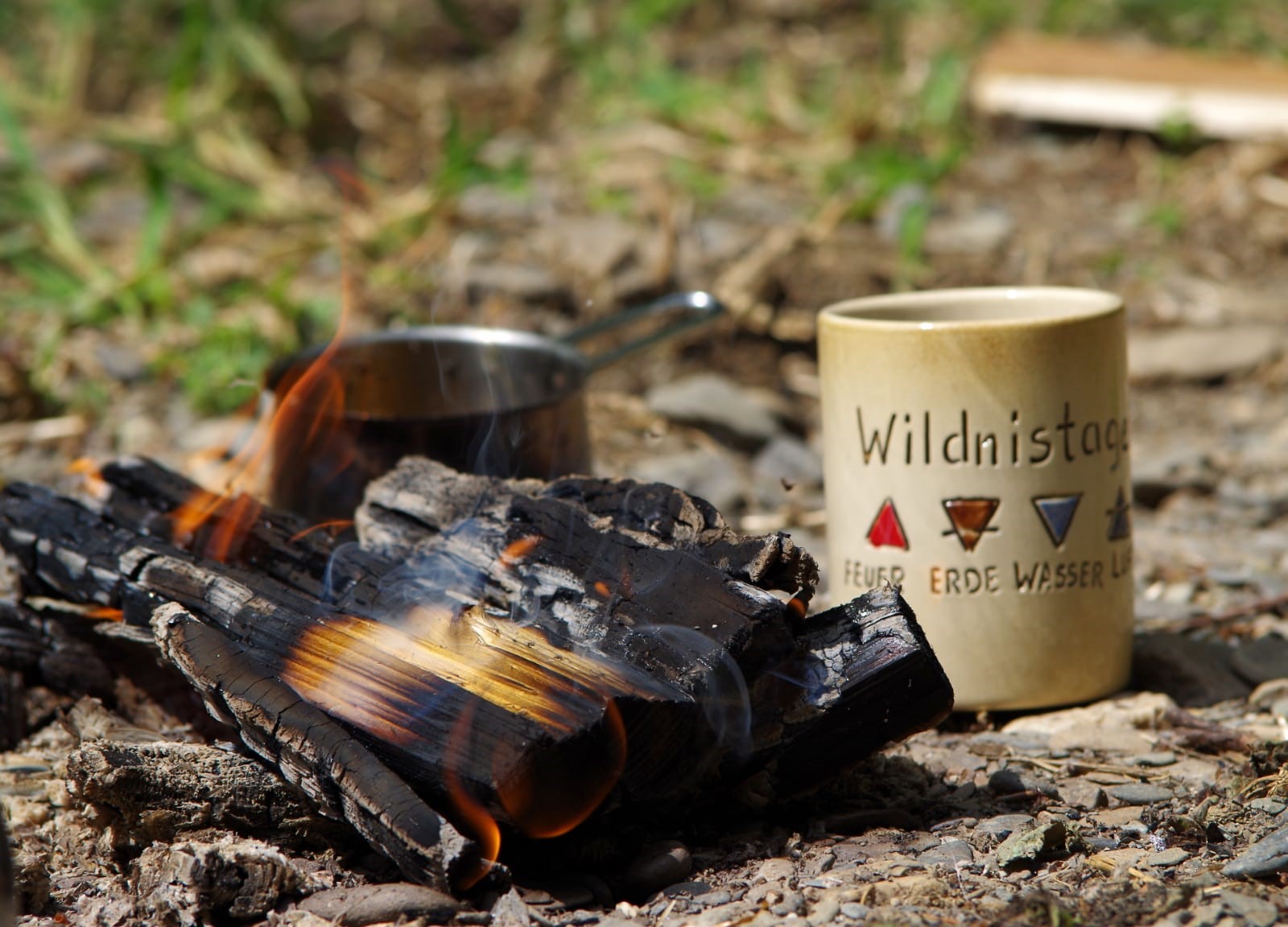 Lagerfeuer mit einer Tasse von Wildnistage